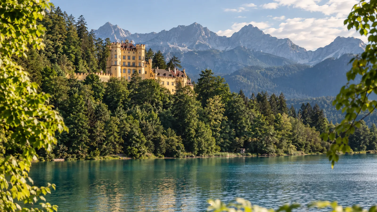 Schloss Hohenschwangau mit gelber Fassade am Ufer des Alpsees